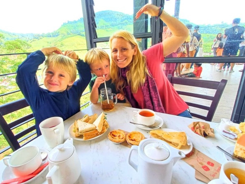 A family enjoying afternoon tea and fresh scones at the BOH Tea cafe, a relaxing bonding experience perfectly suited for your Cameron Highlands day trip.