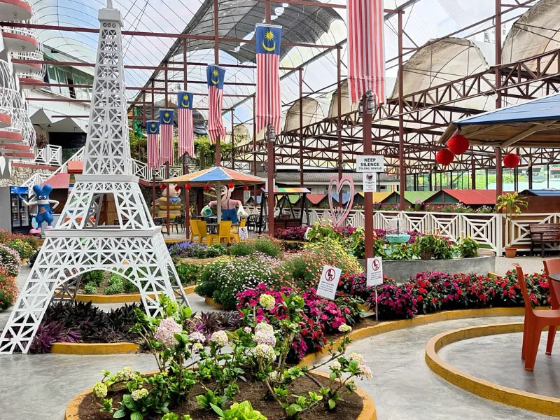 The scenic Kea Garden featuring a mini Eiffel tower and blooming flowers, a relaxing spot next to Kea Farm Market to explore during your Cameron Highlands day trip.