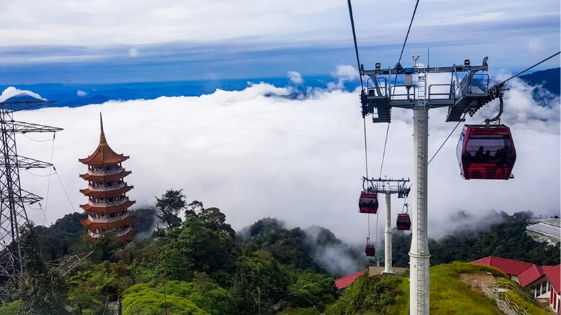 The majestic Chin Swee Temple pagoda and Awana SkyWay cable cars floating above a sea of clouds, a breathtaking view easily accessed on your Genting Highlands day trip private car tour.