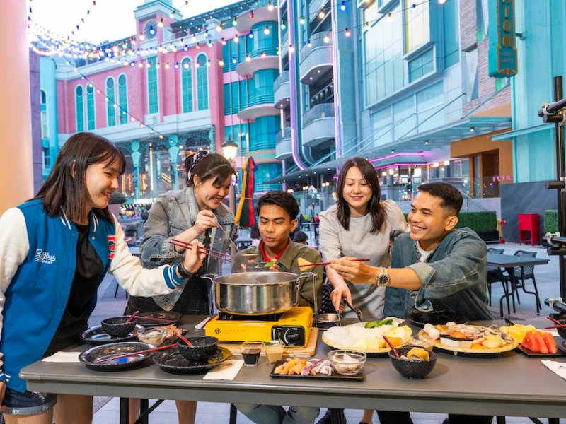 Tourists enjoying outdoor hotpot dining at Gohtong Way, Genting Highlands, a popular night activity easily planned with a Genting Highlands day trip private car.