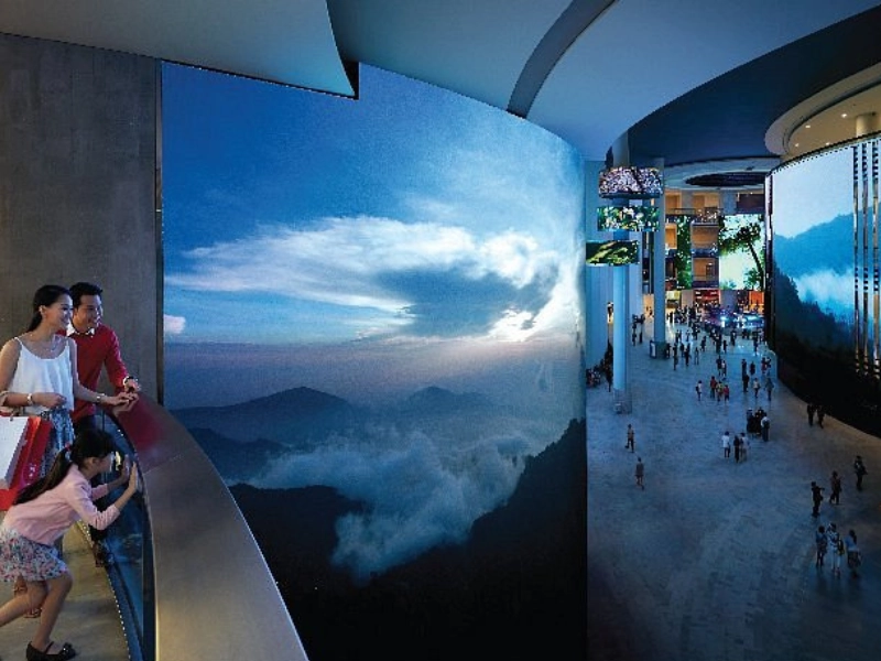 Giant curved LED screens displaying nature scenery at SkyAvenue Mall, a grand indoor landmark easily visited with your Genting Highlands day trip private car service.