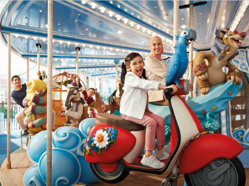 Kids enjoying the magical double-decker Blue Sky Carousel at Genting SkyWorlds Theme Park, a family-friendly attraction perfectly paired with the convenience of your Genting Highlands day trip private car.