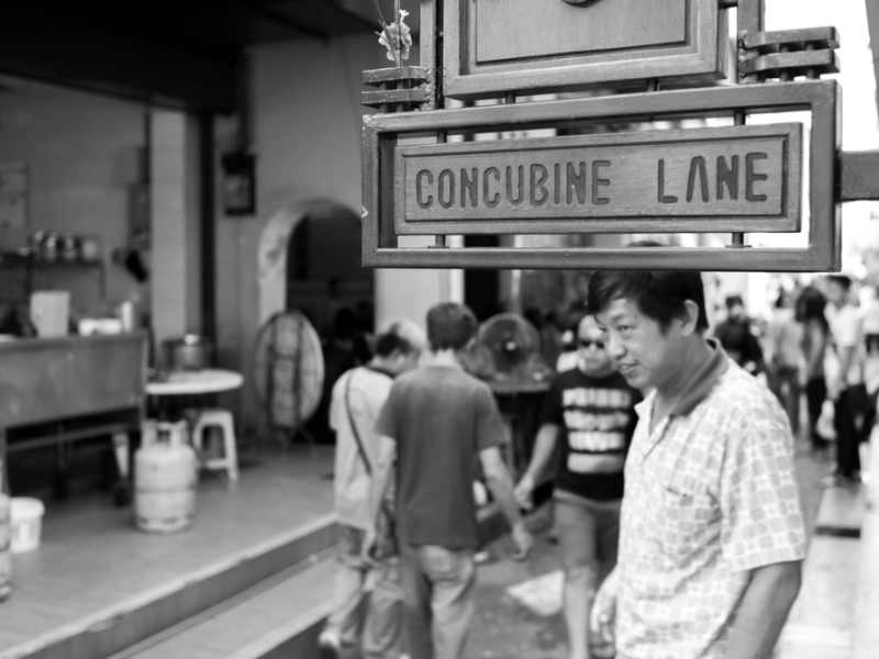 Tourists exploring the historic shops and buying souvenirs at Concubine Lane, a bustling street you can enjoy with hands-free shopping convenience on your Ipoh day trip.