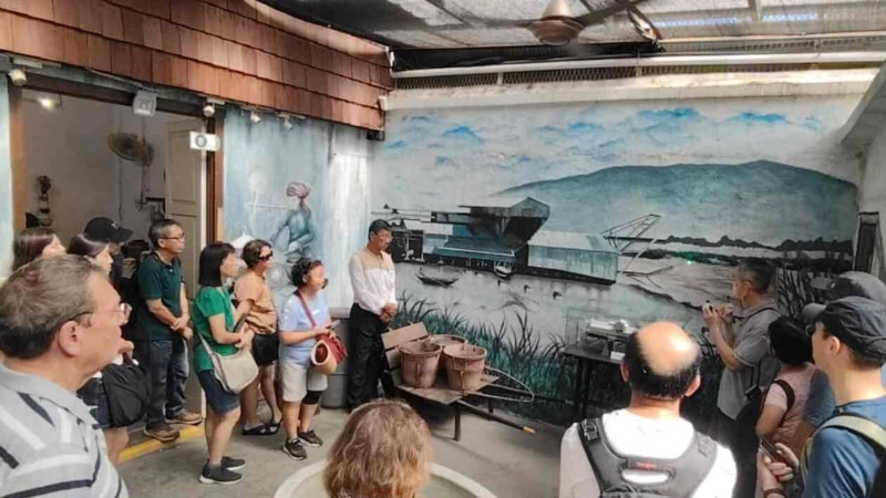 Tourists attending an insightful guided tour about tin mining history at Han Chin Pet Soo, an educational heritage site you can visit with full energy using our stress-free transfer on your Ipoh day trip.