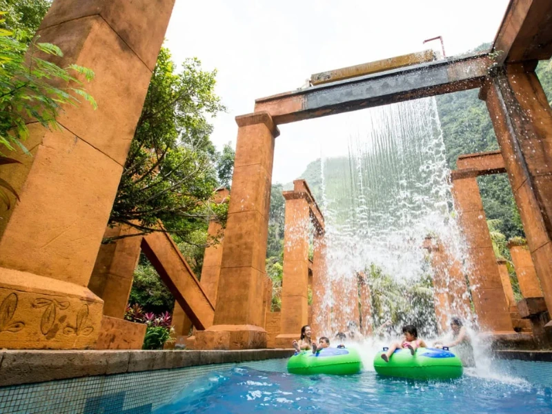 Families enjoying the waterfall and adventure river at Lost World of Tambun, a fun water activity perfectly paired with our relaxing private transfer on your Ipoh day trip.