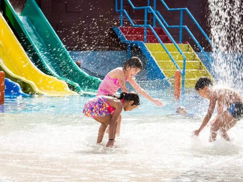 Kids having splashing fun at the Lost World of Tambun water park, a joyful family activity followed by a comfortable nap in our private car on your Ipoh day trip.