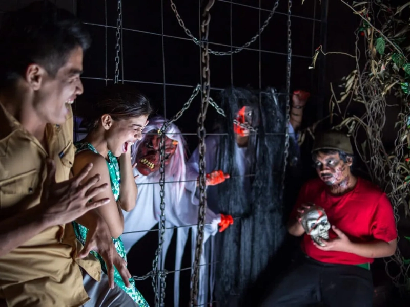 Tourists screaming at the Haunted Chambers during Screamfest at Lost World of Tambun, a thrilling night activity perfectly followed by a safe ride home in our private car on your Ipoh day trip.