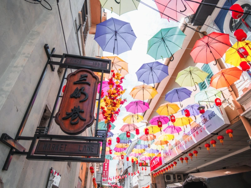 Colorful umbrellas hanging above Market Lane, a picturesque photo spot you can visit with hassle-free drop-offs during your Ipoh day trip.