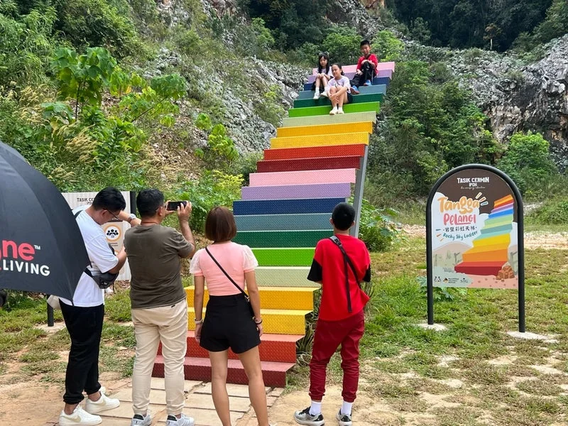 The colorful Rocky Sky Ladder against limestone cliffs at Tasik Cermin, a vibrant photo spot you can visit in the cool morning during your flexible Ipoh day trip.