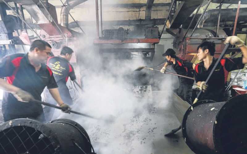 The traditional process of roasting authentic coffee beans, a fascinating cultural heritage you can easily discover with a local driver on your Ipoh day trip.