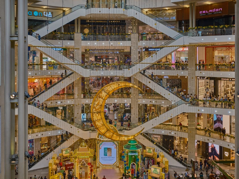 The magnificent intersecting escalators and festive crescent moon decoration inside Pavilion KL, a premier shopping haven perfectly suited for your Kuala Lumpur day trip private car itinerary.