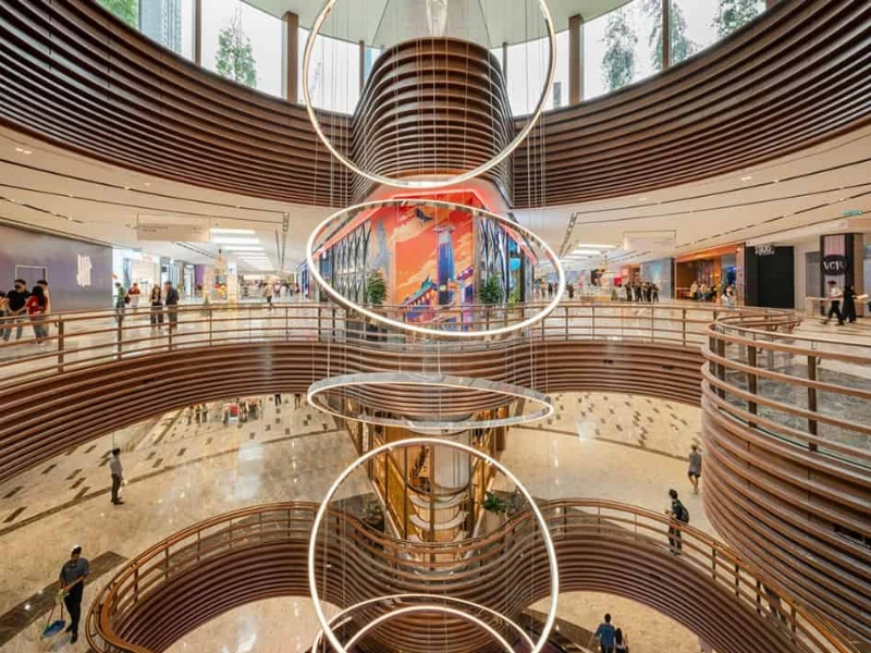 The iconic circular halo chandeliers and curved architecture inside The Exchange TRX, an elegant shopping highlight effortlessly reached with your Kuala Lumpur day trip private car.