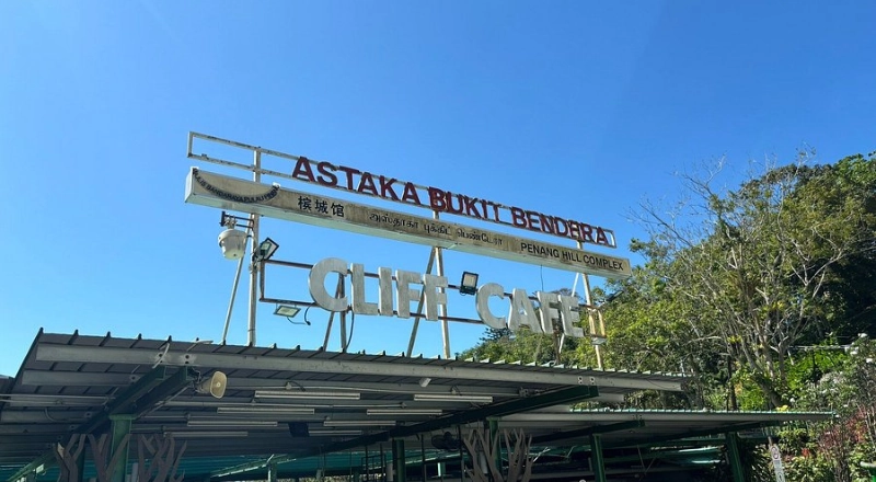 Tourists enjoying authentic street food at Astaka Bukit Bendera on Penang Hill, a delicious stop on your Penang Day Trip made completely relaxing with our private car.