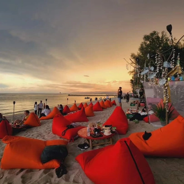 Relaxing on orange bean bags at Frandy Beach Bar in Batu Ferringhi during sunset, a perfect evening you can enjoy with a safe designated driver on your Penang Day Trip private car.
