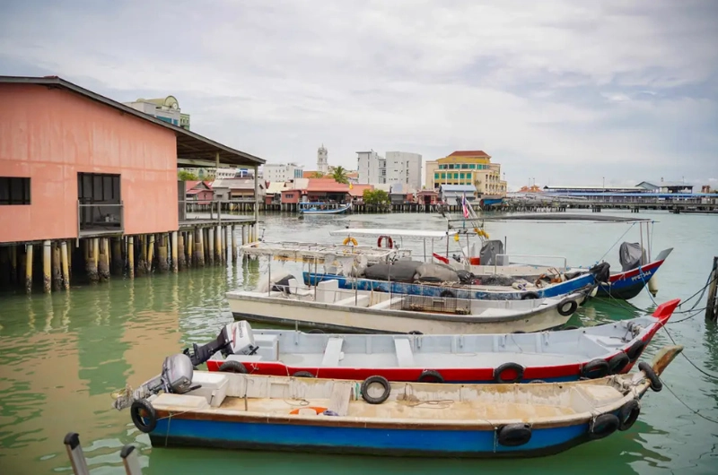 Traditional boats and wooden stilt houses at Chew Jetty, a UNESCO water village you can explore comfortably without parking stress on your Penang Day Trip by private car.