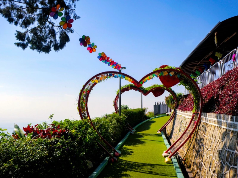 Families and couples enjoying the Love Arch at Little Village on Penang Hill, a delightful spot on your Penang Day Trip made completely stress-free with our private car.