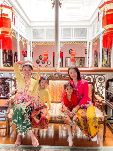 Tourist wearing vibrant Kebaya for a photography session inside the historic Pinang Peranakan Mansion, an Instagrammable experience kept fresh and comfortable on your Penang Day Trip private car tour.