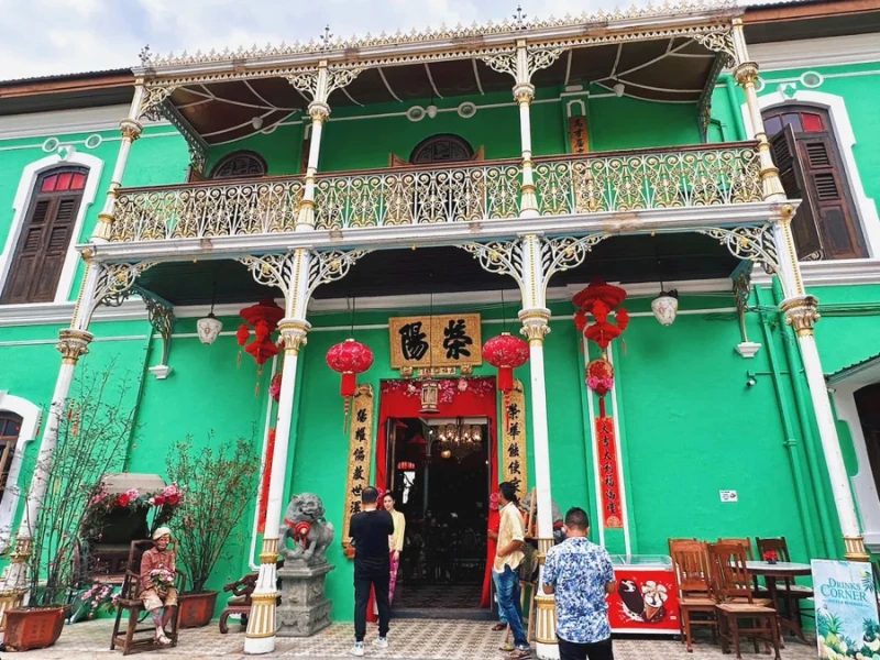 The elegant green exterior of Pinang Peranakan Mansion, a stunning Baba Nyonya museum where you can arrive looking fresh and camera-ready on your Penang Day Trip private car.