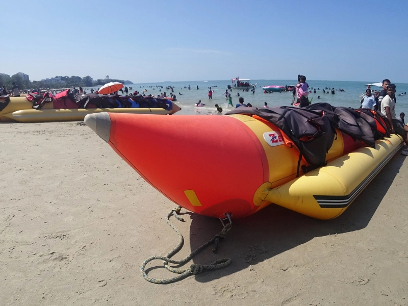 Exciting banana boat ride and water sports at Teluk Kemang beach, a thrilling adventure easily added to your Port Dickson day trip private car itinerary.
