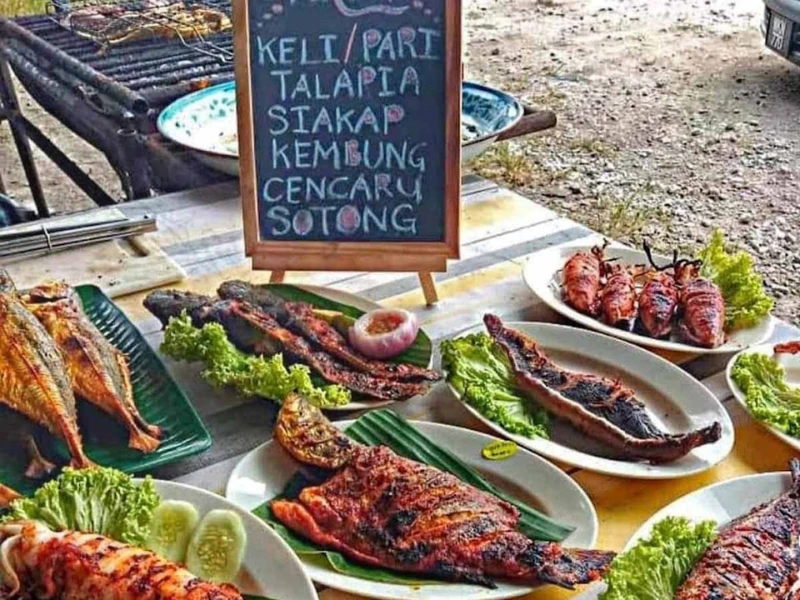 The authentic Abah Bonda Ikan Bakar stall serving fresh grilled seafood, a hidden gem easily reached with the door-to-door convenience of your Sekinchan day trip private car.