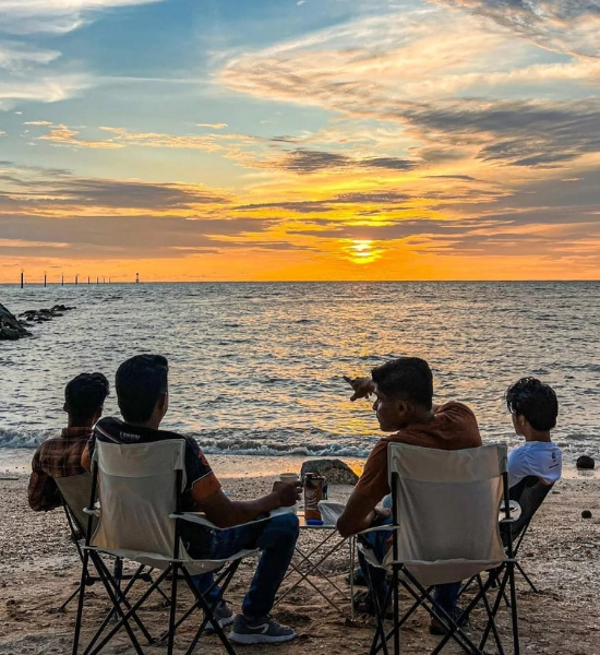 Friends chilling and watching the stunning sunset at Pantai Redang, a relaxing 'lepak' experience you can fully enjoy with the flexible schedule of your Sekinchan day trip private car.
