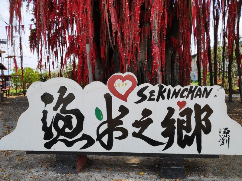 The famous Wishing Tree with red ribbons at Pantai Redang, a landmark of the 'Land of Fish and Rice' you can visit on your flexible Sekinchan day trip private car tour.