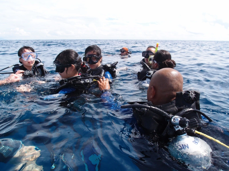 Group of divers preparing for an underwater adventure at Tioman Island, easily accessible via our spacious Singapore to Mersing day trip private car.